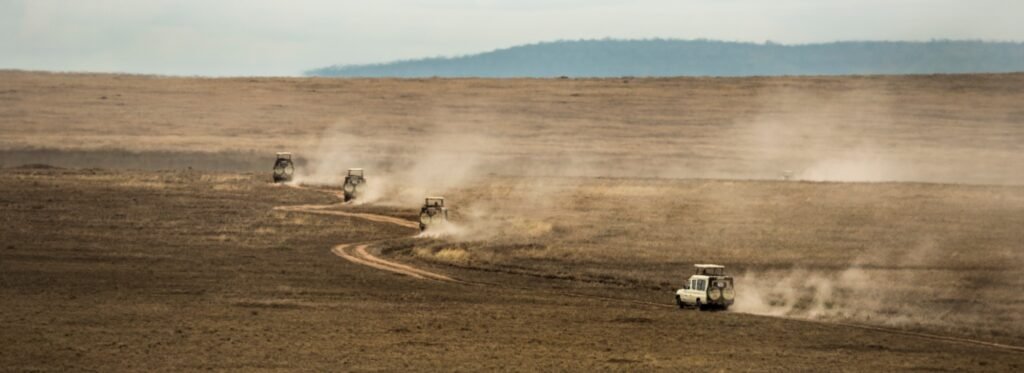 Benson Safaris | Safari jeeps crossing Serengeti, Tanzania, Africa