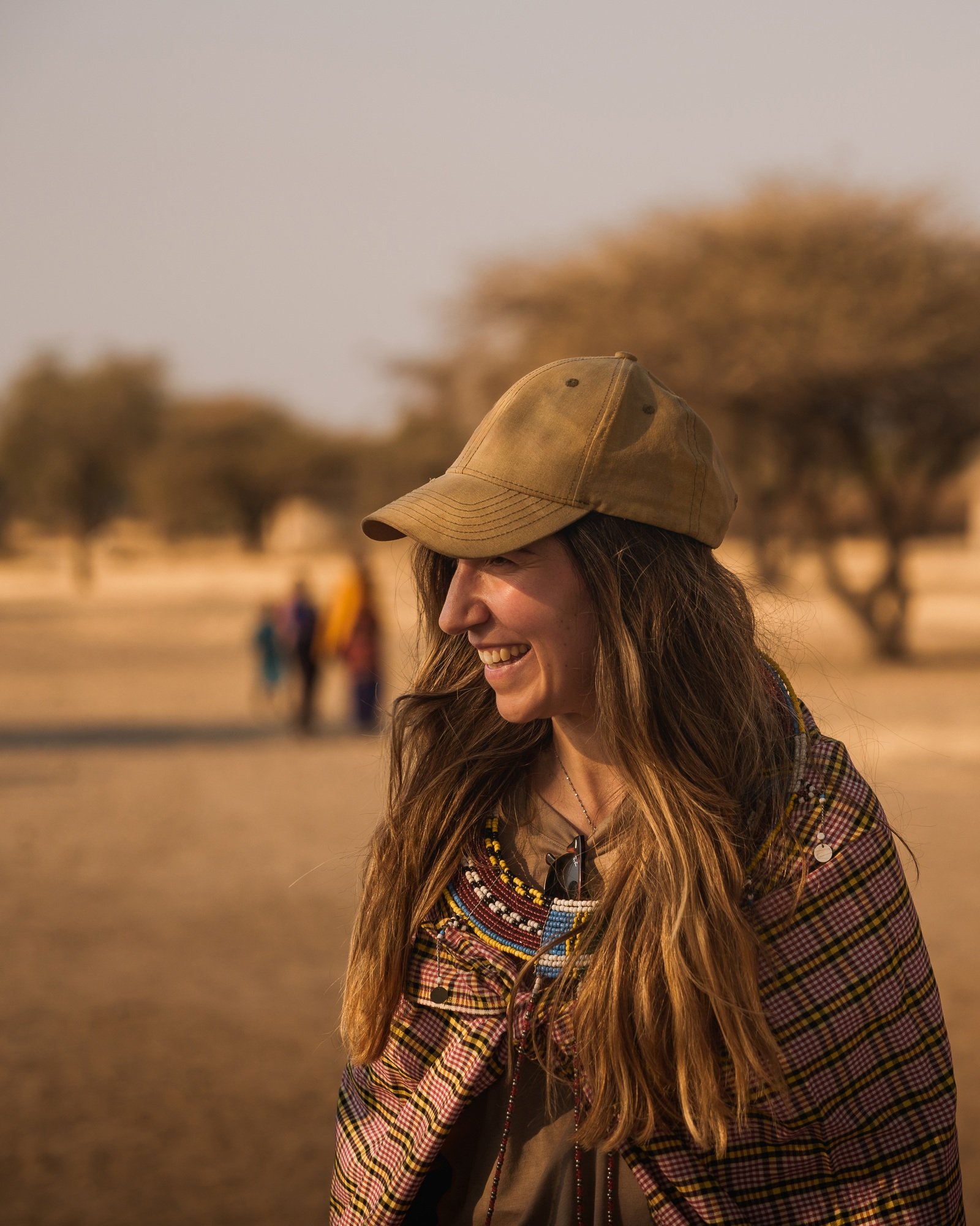 Benson Safaris | Tourist smiling and wearing traditional maasai clothes in tanzania, africa