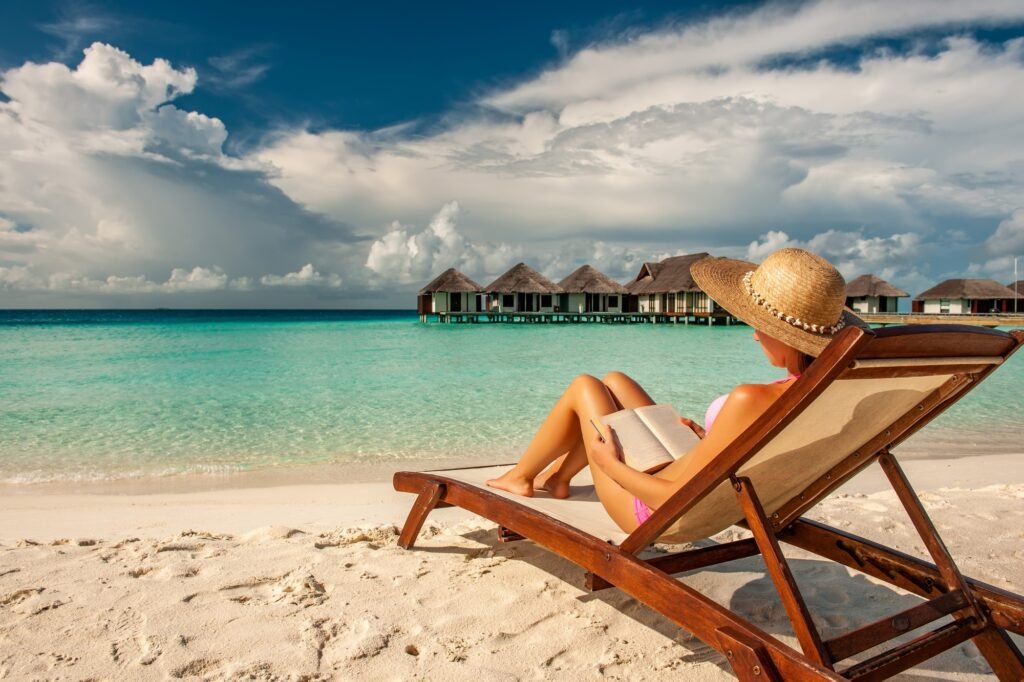 Benson Safaris | Young woman reading a book at beach