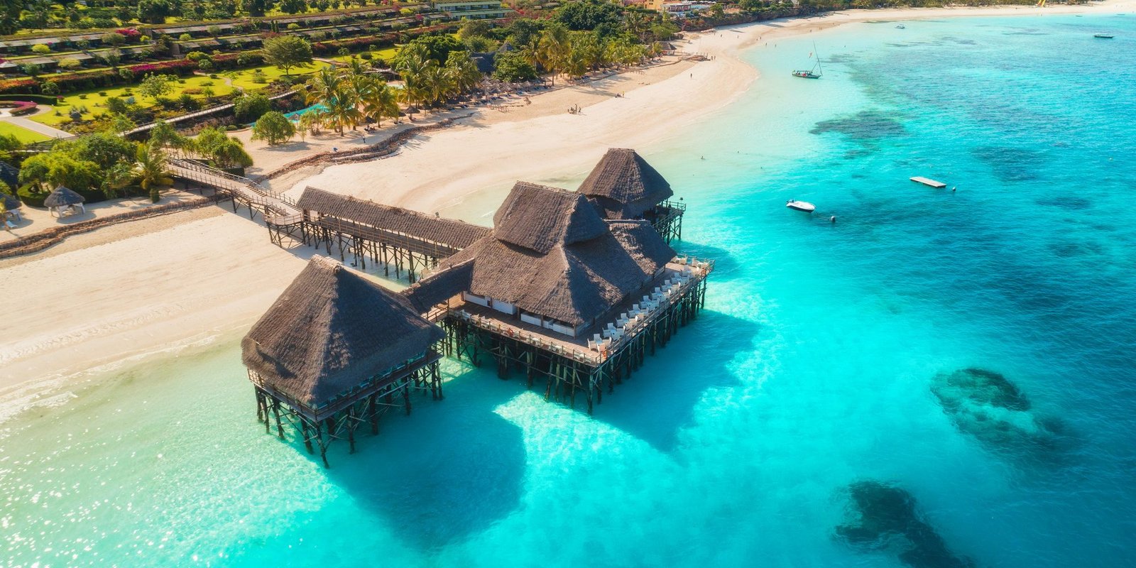 Benson Safaris | Aerial view of beautiful hotel on the water in ocean at sunset