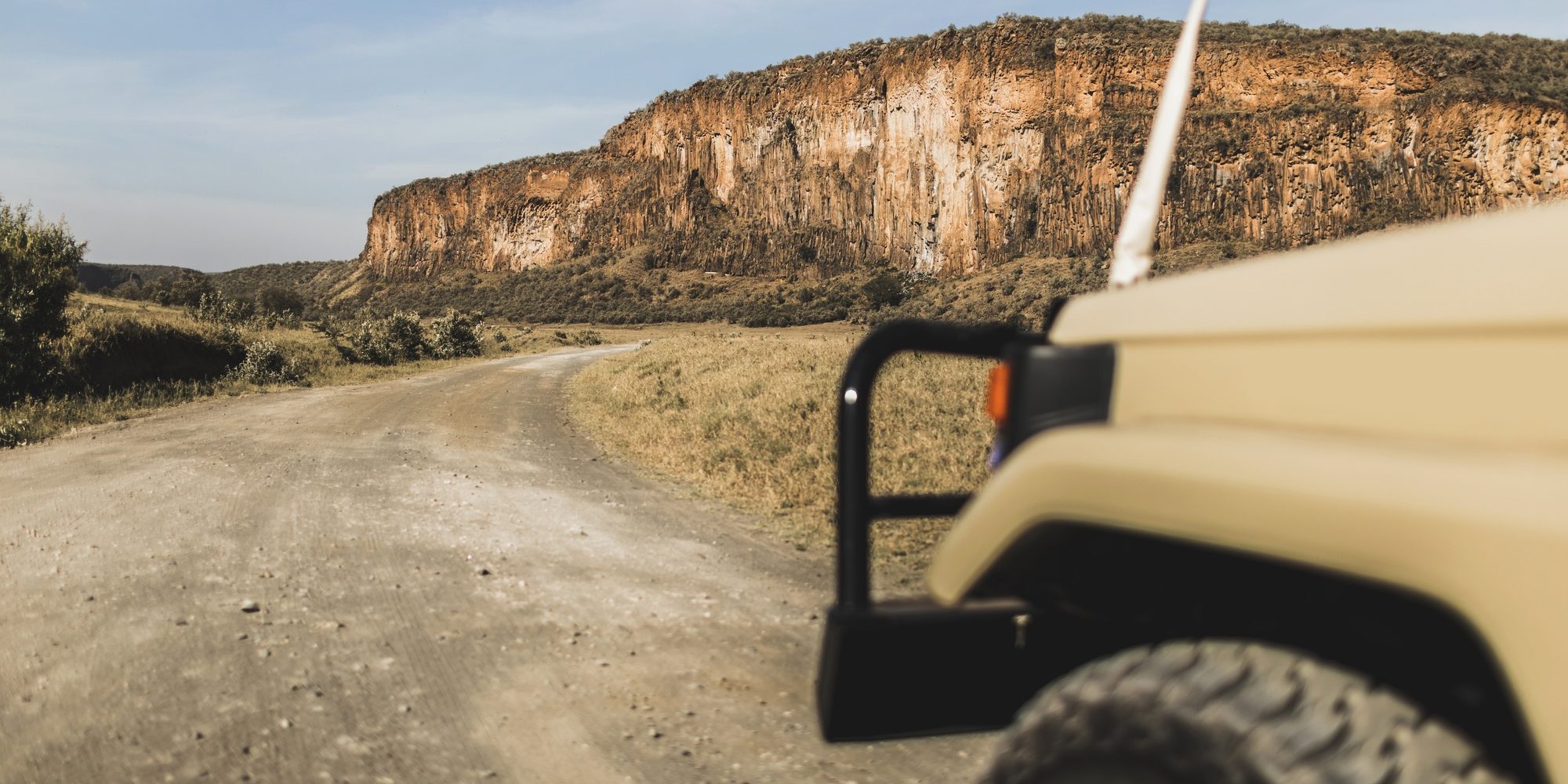 Benson Safaris | Safari in Hell's Gate national park in Kenya. Off road jeep car, savannah and mountain view